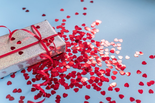 Confezione regalo di San Valentino con glitter a forma di cuore rosso su sfondo blu