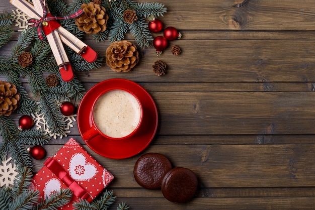 Confezione regalo e caffè con decorazioni natalizie su fondo in legno