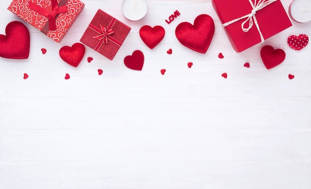 Confezione regalo e cuore rosso su fondo di legno bianco con lo spazio della copia per il matrimonio di amore o il giorno di San Valentino.