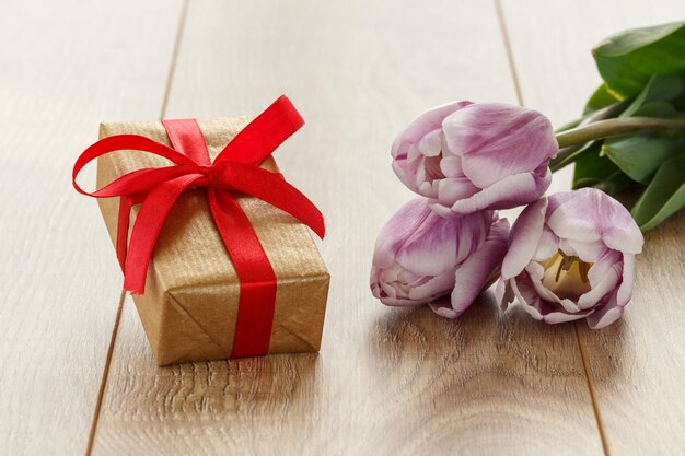 Confezione regalo e fiori su tavole di legno