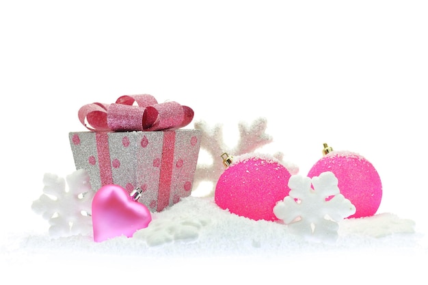 Confezione regalo e ornamenti natalizi rosa sulla neve