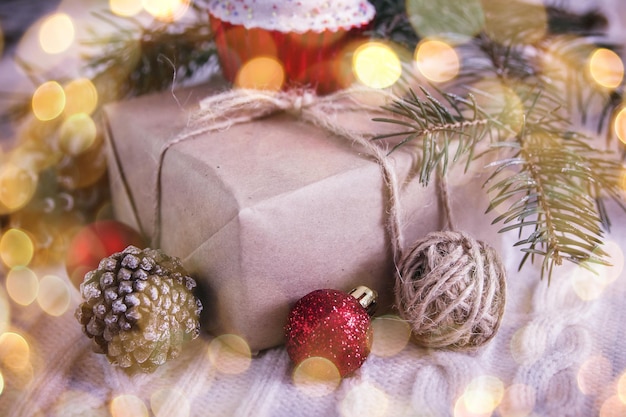 Confezione regalo e ramo di albero di natale e decorazioni su sfondo bianco effetto bokeh da una ghirlanda