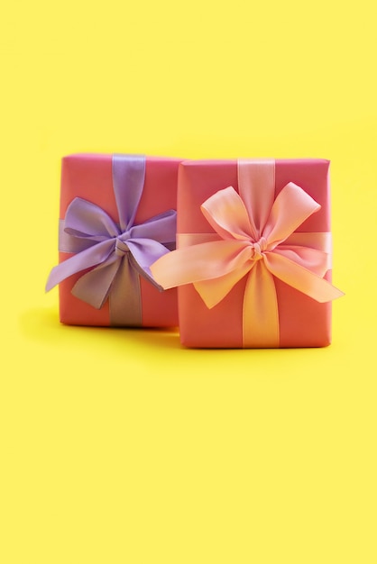 Confezione regalo fiocco rosa su sfondo giallo Decorazione festosa design