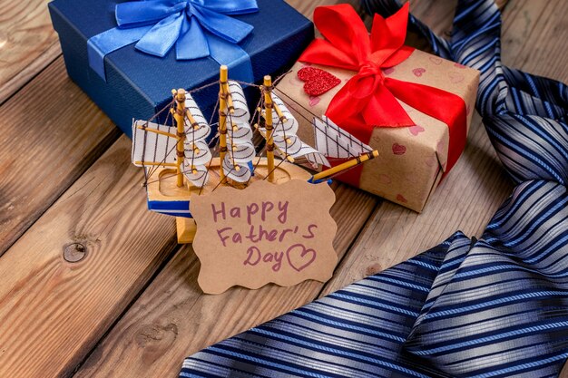 Confezione regalo per la festa del papà felice con cravatta su uno sfondo di legno rustico. Biglietto d'auguri