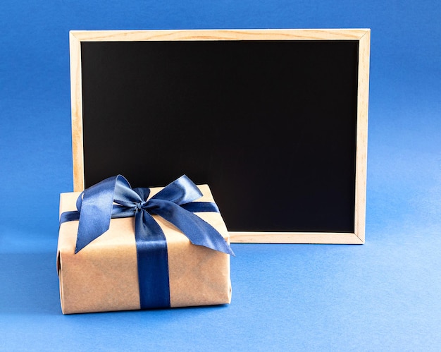 Confezione regalo per la festa del papà felice con nastro blu e cornice nera per il testo di saluto