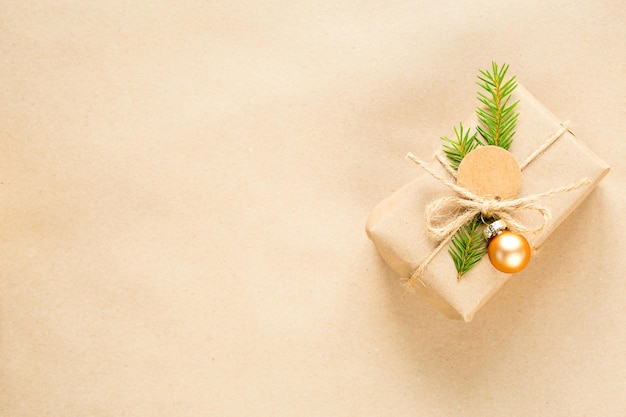 Confezione regalo per Natale e Capodanno in materiali ecologici: carta kraft, rami di abete vivo, pigne, spago. Etichette con mock up, decoro naturale, fatte a mano, fai da te. Piatto, sfondo, cornice, minimalismo