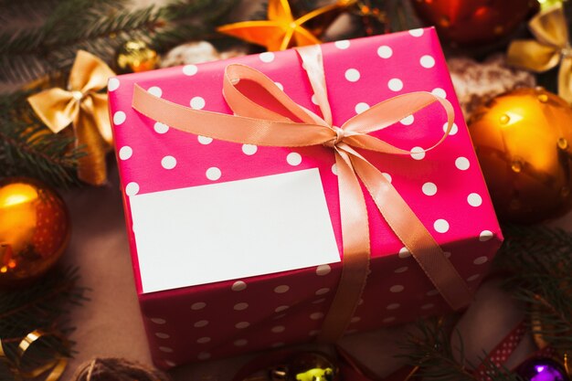 Confezione regalo rosa con scheda in bianco sotto l'albero di Natale