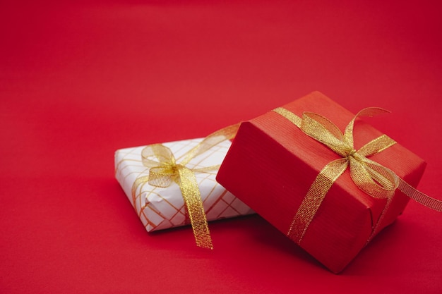 Confezione regalo rossa e bianca con nastri dorati. Confezione regalo di Natale. Isolato su sfondo rosso