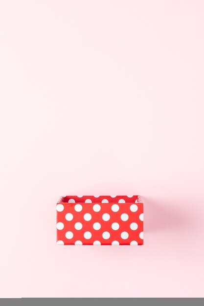 Confezione regalo rossa sulla superficie rosa.