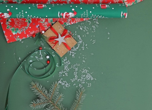 confezione regalo su sfondo verde, accanto a un ramo di un albero di Natale