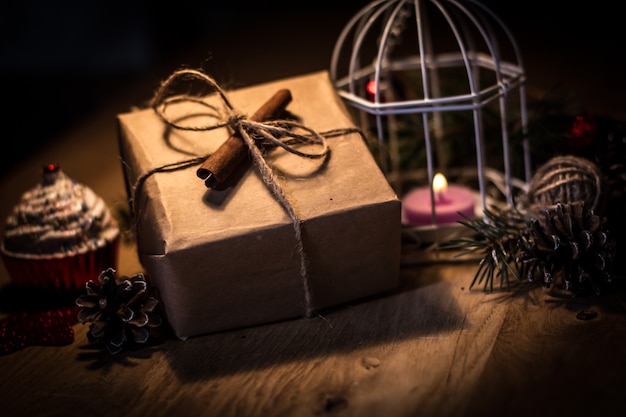 Confezione regalo vintage e candela su sfondo natalizio