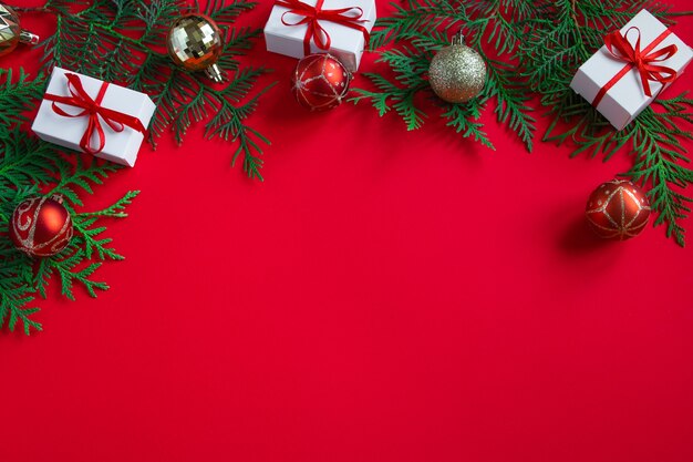 Confezioni regalo e decorazioni festive. Composizione in Natale su sfondo rosso. Posto per il testo.