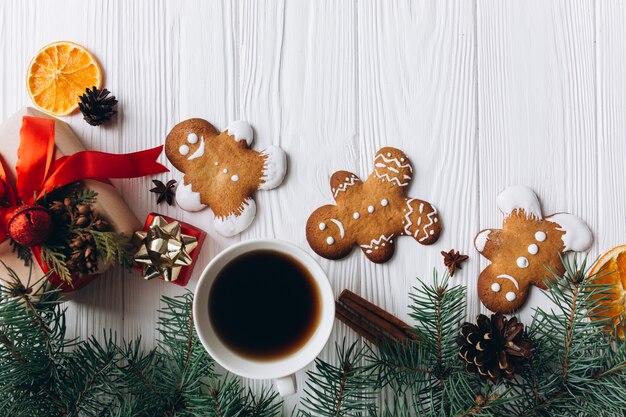 Confine natalizio. Biscotti, spezie e decorazioni del pan di zenzero su fondo di legno bianco.