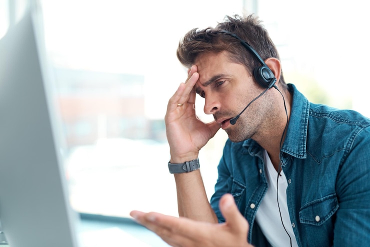 Foto confuso call center e uomo con cuffie computer e consulenza per parlare in agenzia e servizio clienti connessione scrivania e perplesso nella comunicazione in ufficio e ascolto di telemarketing