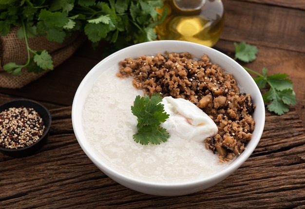 Congee con carne di maiale e uova su alimenti a base di legno