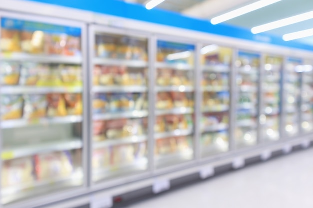 Congelatore commerciale dei frigoriferi del supermercato che mostra il fondo astratto della sfuocatura degli alimenti congelati