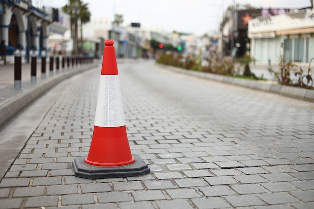 Coni arancioni a strisce sulla strada asfaltata