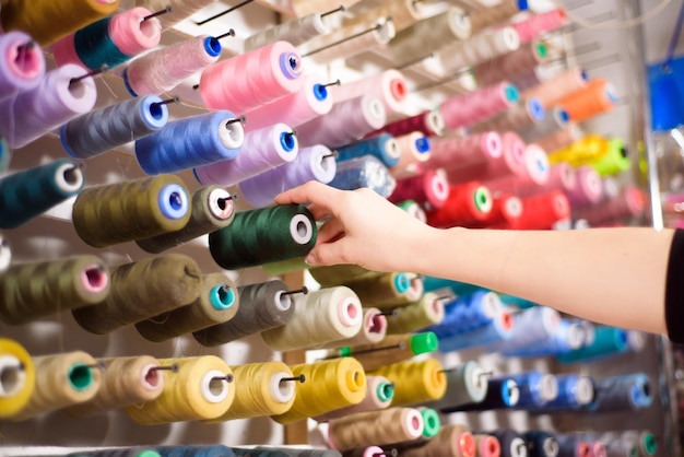 Coni colorati e rocchetti di filo in un atelier di sartoria per designer dell'industria dell'abbigliamento concep
