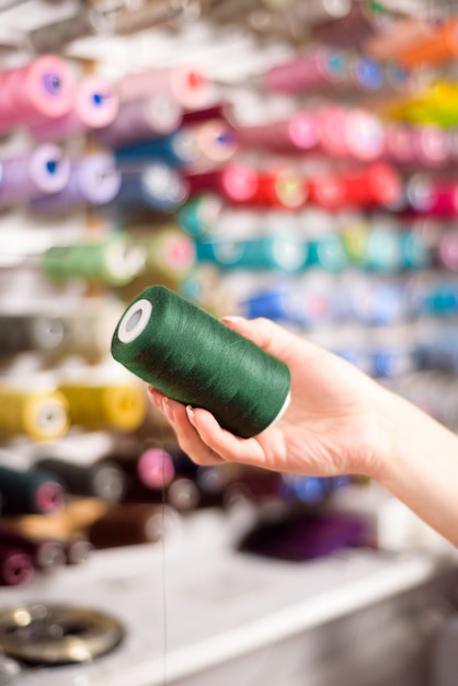 Coni colorati e rocchetti di filo in un atelier Sartoria, industria dell'abbigliamento, concetto di laboratorio di design.