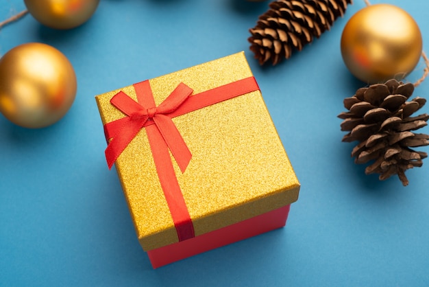 Coni di scatole regalo d'oro e palline di Natale su sfondo azzurro