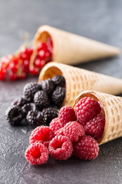 Coni gelato con frutti di bosco su uno sfondo di pietra