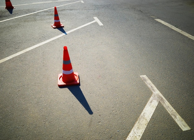 Coni stradali su linee di trasporto di parcheggio vuote sullo sfondo