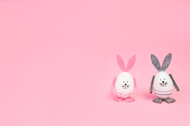 Coniglietti pasquali di Pasqua con le proprie mani su un mocap sfondo rosa