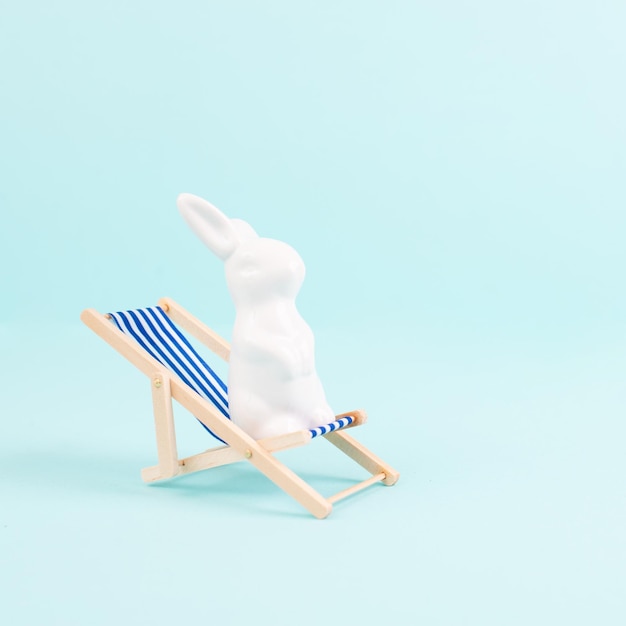 Coniglietto o coniglio seduto sulla sedia a sdraio, vacanze di pasqua, vacanze al mare
