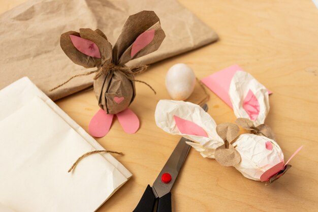 Coniglietto pasquale fatto di un uovo di gallina marrone e carta artigianale nelle mani di una ragazza, primo piano
