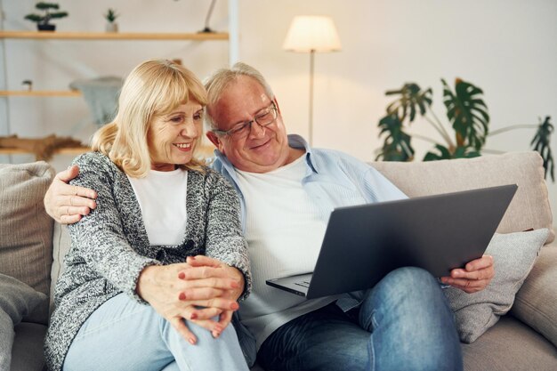 Connessione a Internet Uso del laptop L'uomo anziano e la donna sono insieme a casa