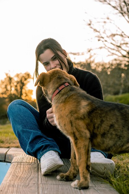 Connessione di sguardi di una giovane ragazza vestita in abiti casuali e il suo cucciolo di cane nel giardino