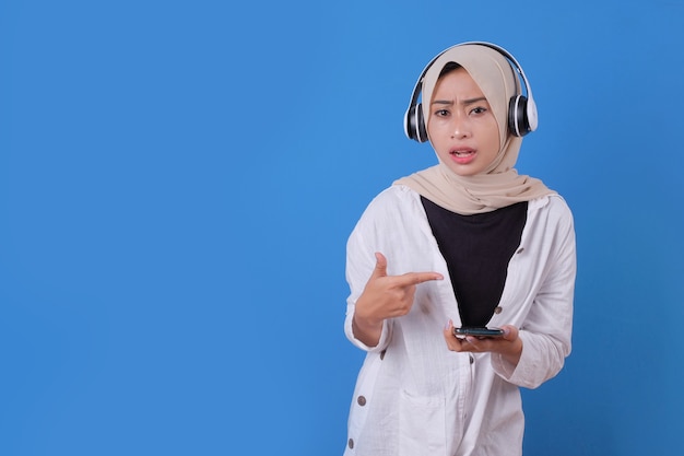 Connessione senza fili. ritratto di giovane donna in posa isolato su musica d'ascolto blu