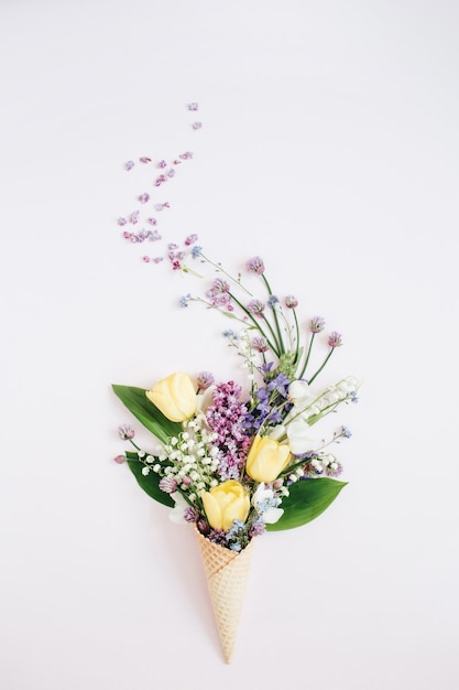 Cono di cialda con fiore lilla, mughetto, bouquet di tulipani rosa