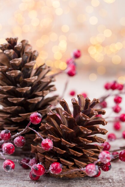 Cono di Natale con bacche rosse su uno sfondo bokeh di fondo.