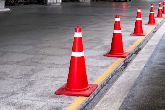 Cono di traffico arancione o imbuto in piedi una fila al parcheggio