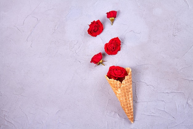 Cono gelato a cialda con fiori di rosa vista dall'alto piatto