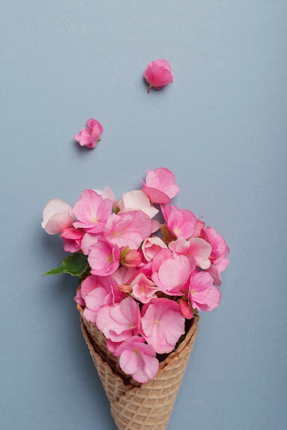 Cono gelato con fiori di begonia rosa