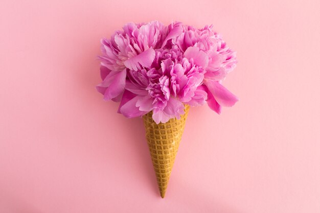 Cono gelato con peonie rosa al centro del rosa