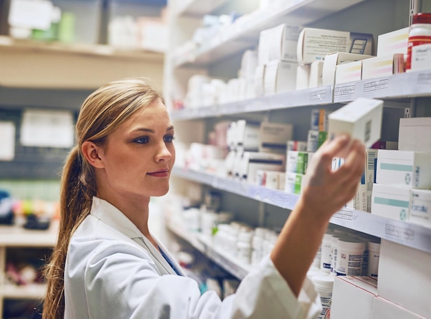 Conosco esattamente il farmaco che ti aiuterà. Inquadratura di un farmacista che guarda un farmaco su uno scaffale