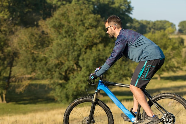 Conquista delle vette da ciclista in pantaloncini e maglia su una moderna bici hardtail in carbonio