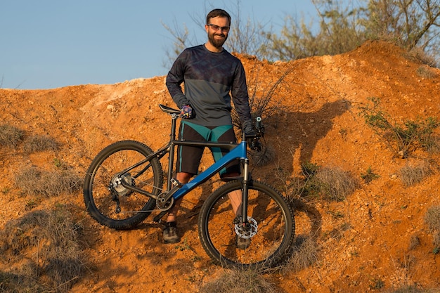 Conquista delle vette da ciclista in pantaloncini e maglia su una moderna bici hardtail in carbonio