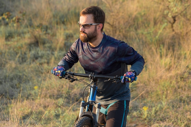 Conquista delle vette da ciclista in pantaloncini e maglia su una moderna bici hardtail in carbonio