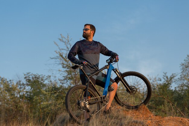 Conquista delle vette da ciclista in pantaloncini e maglia su una moderna bici hardtail in carbonio