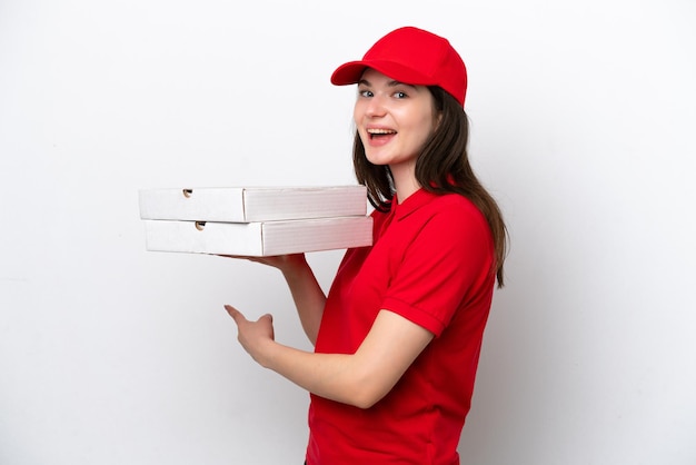 Consegna della pizza giovane russa che raccoglie scatole di pizza isolate su sfondo bianco che punta all'indietro
