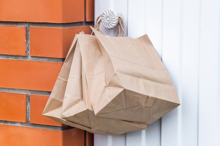 Consegna senza contatto sicura. sacchi di carta sulla maniglia della porta di casa. Ordine online. consegna senza contatto degli ordini in quarantena