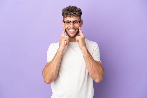 Consegna uomo caucasico isolato su sfondo viola sorridente con un'espressione felice e piacevole