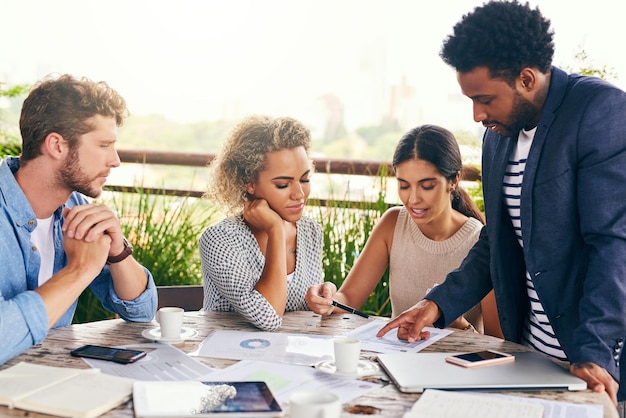 Consente di esplorare di più in questa idea Scatto di un gruppo di uomini d'affari che hanno una riunione all'aperto