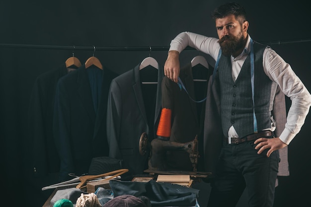 Considerando il codice di abbigliamento aziendale del passaggio successivo Meccanizzazione del cucito fatta a mano Laboratorio di sartoria retrò e moderno Uomo barbuto sarto giacca da cucire negozio di abiti e showroom di moda Cucito su misura