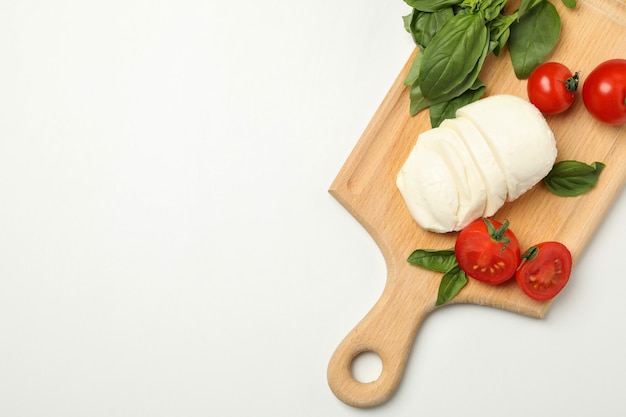 Consiglio con mozzarella, pomodoro e basilico su sfondo bianco