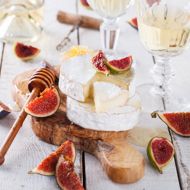 Consiglio di formaggi, camembert con fichi e miele e vino bianco